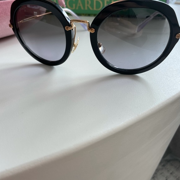 Miu Miu circular glasses in black and gold